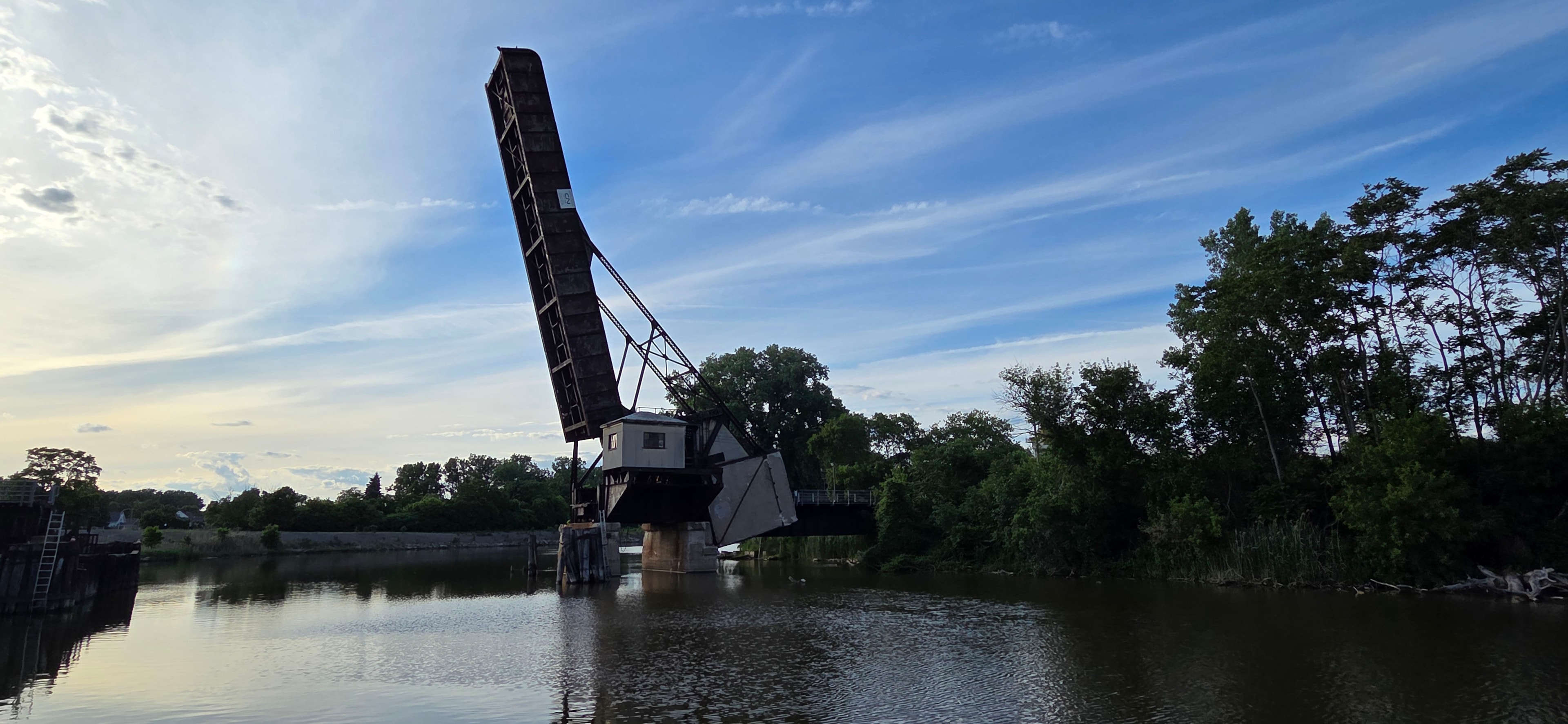 The Black River Bridge over calm water at dusk